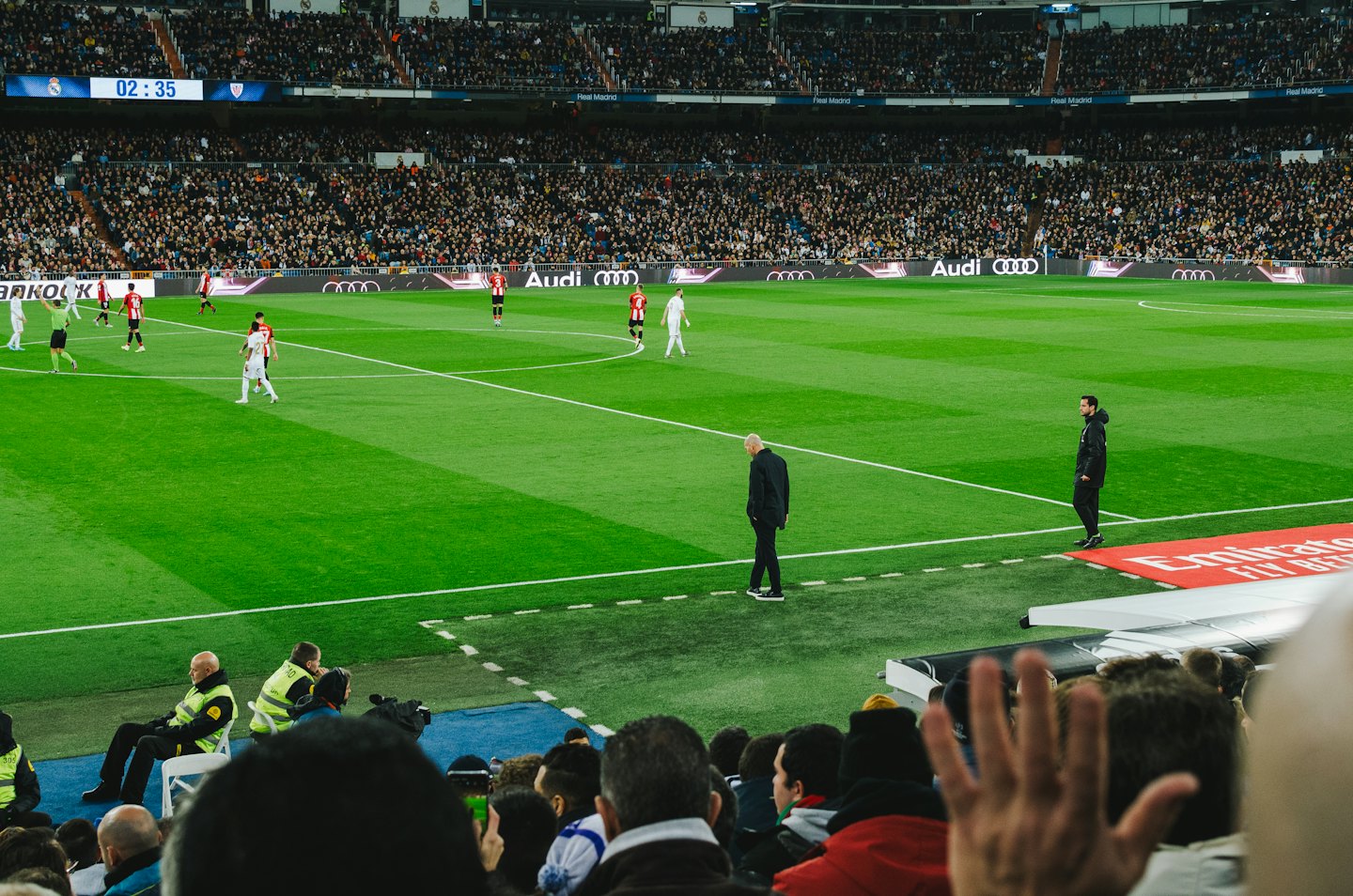 Giocatori di calcio competono su un campo verde in uno stadio gremito.
