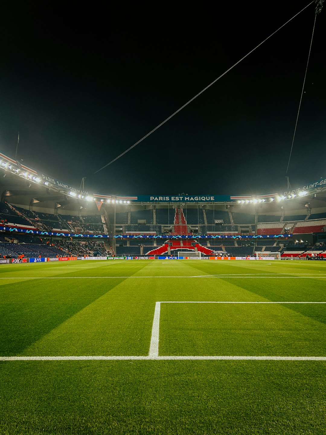 Campo di uno stadio di calcio vuoto di notte con luci brillanti.